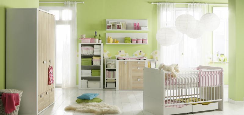 Minicuna blanca con barras protectoras desplazables y cajones de almacenamiento